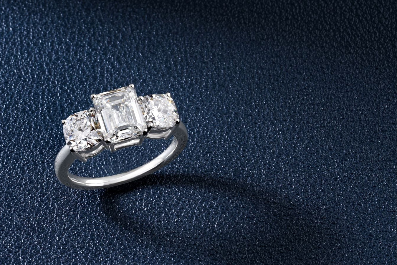 Diamond ring on a dark blue textured fabric background