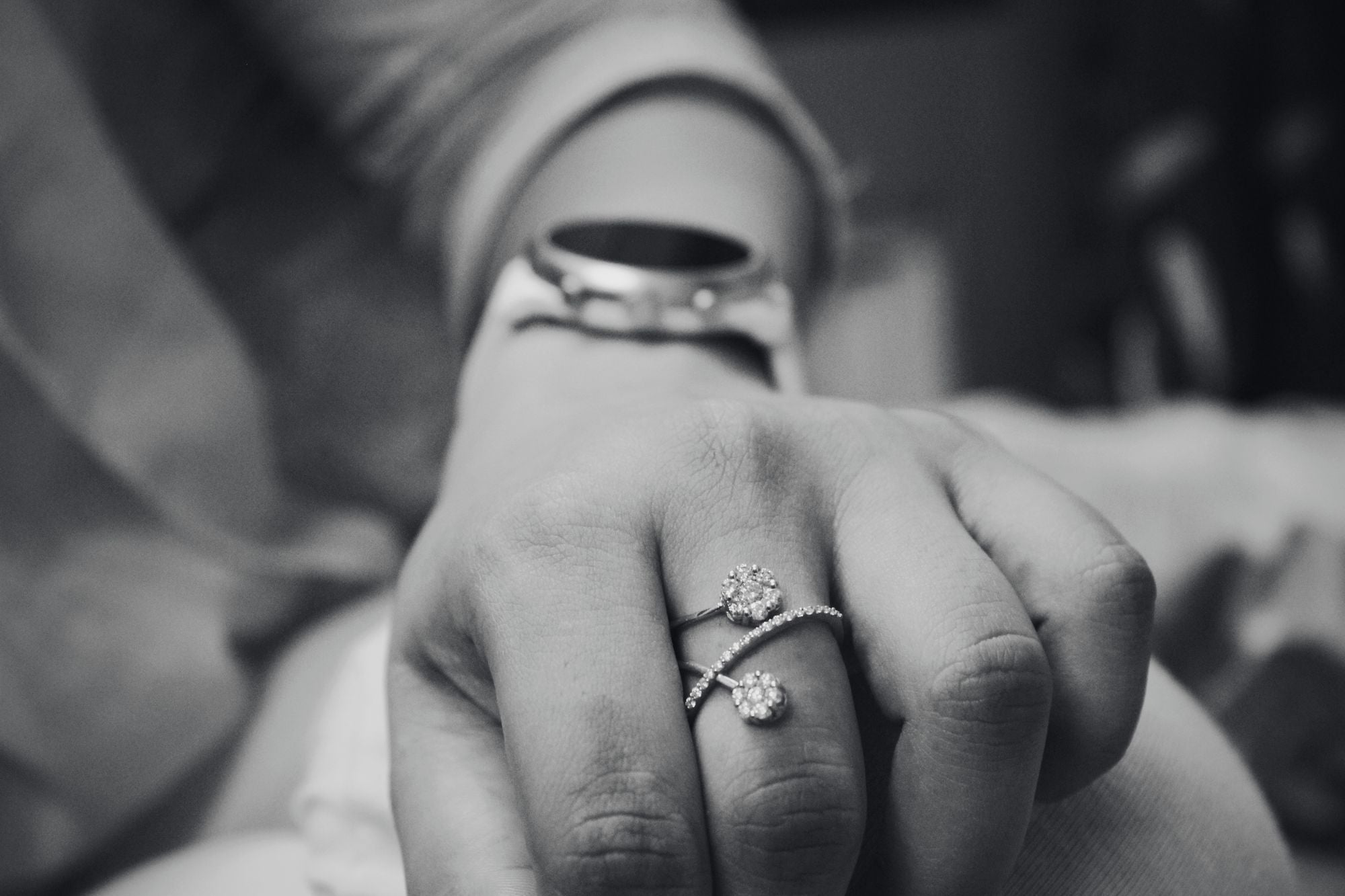 Close-up of a hand wearing two rings with a blurred background